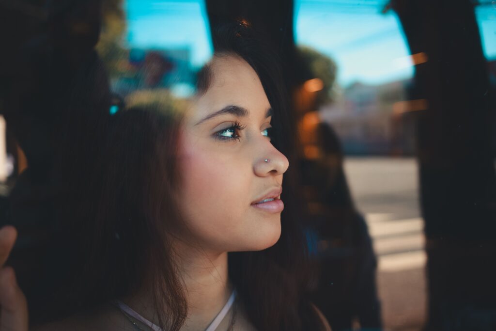 Woman standing peacefully in soft morning light, representing inner knowing, self-trust, and quiet confidence.