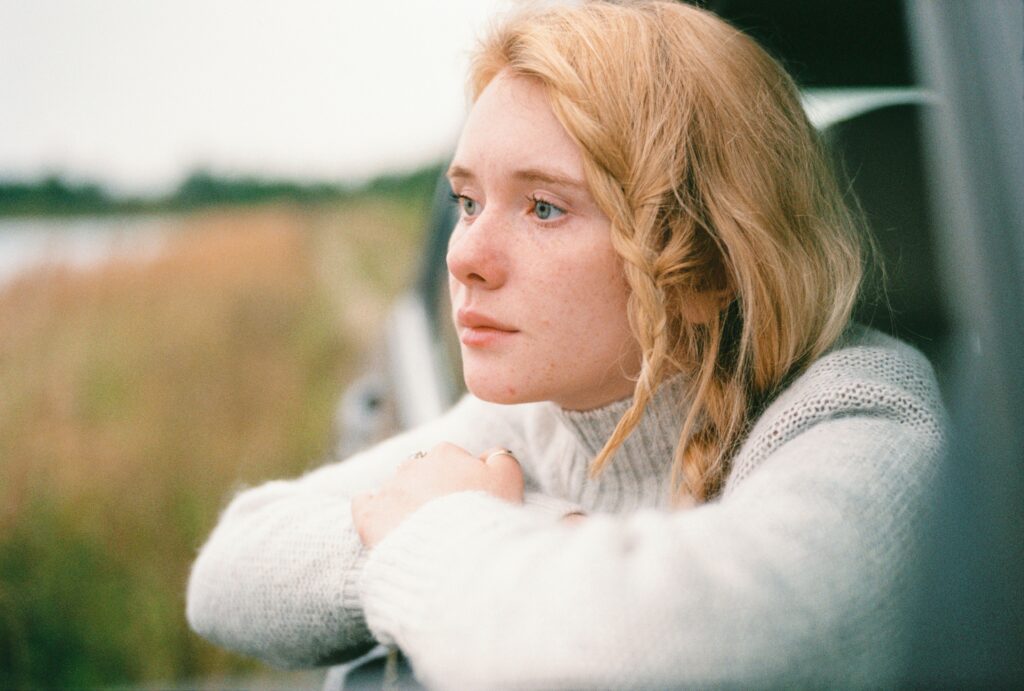 Woman reflecting peacefully in natural light after finding herself and remembering who she is